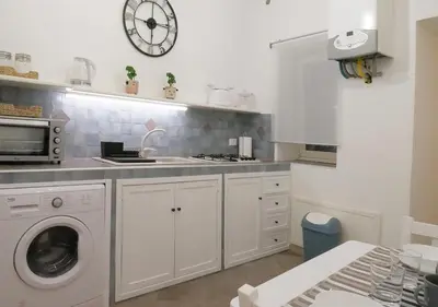 a kitchen with a sink and a washing machine at Casa Kilò in Palermo