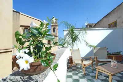 a balcony with a plant and a table and chairs at Casa Azul in Terrasini