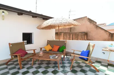 a patio with chairs and a table and an umbrella at Casa Azul in Terrasini