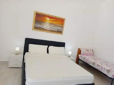 a bedroom with a white bed and a couch at Villa Rosa in Castellammare del Golfo