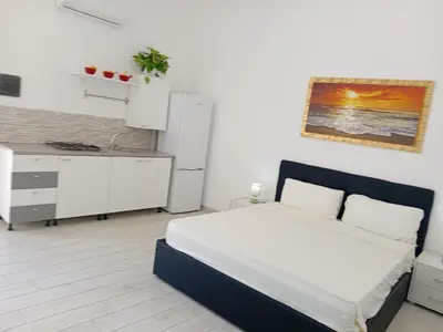 a small bedroom with a bed and a kitchen at Villa Rosa in Castellammare del Golfo