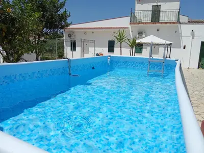 a large blue swimming pool with a swing in it at Villa Rosa in Castellammare del Golfo