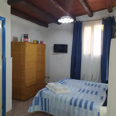 a bedroom with a blue and white bed and a wooden cabinet at Dolce Casa in Palermo