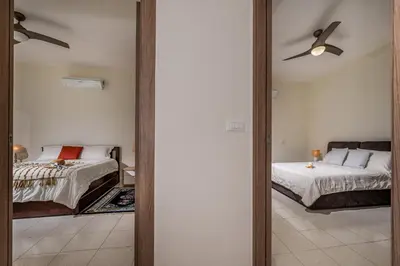 a bedroom with two beds and a mirror at Villa Azuria con Piscina Privata Vista Mare in Scopello