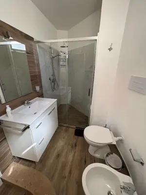 a bathroom with a toilet and a sink and a shower at Trentuno Mondello Apartments in Mondello