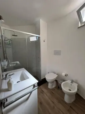 a white bathroom with a sink and a toilet at Trentuno Mondello Apartments in Mondello