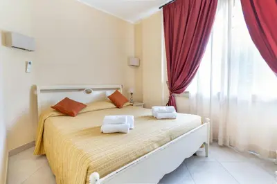 a bedroom with a large bed with red curtains at La Casa di Martorana in Palermo
