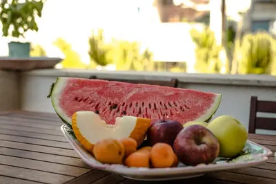 a plate of fruit on a wooden table at Casa Vespucci in Isola delle Femmine