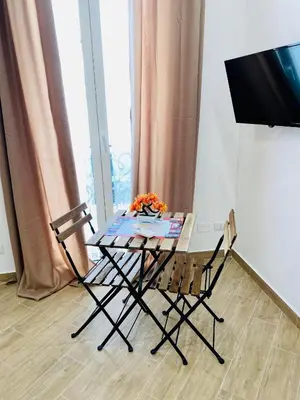 a table and two chairs in a room with a television at Pindemonte Suites in Palermo