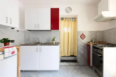 a kitchen with white cabinets and a sink at Iconic Apartment in Porta Carini by Wonderful Italy in Palermo