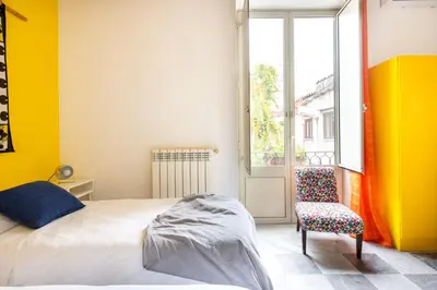 a bedroom with a bed and a chair and a window at Iconic Apartment in Porta Carini by Wonderful Italy in Palermo
