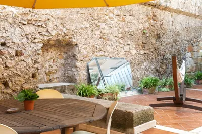 a wooden table with chairs and an umbrella on a patio at Iconic Apartment in Porta Carini by Wonderful Italy in Palermo