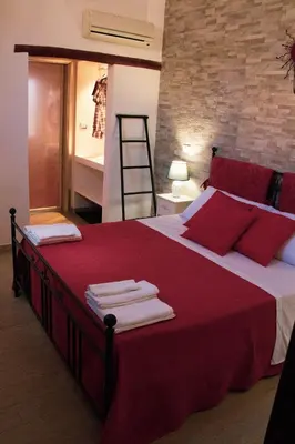 a bedroom with a large red bed with towels on it at DAI MORI in Palermo
