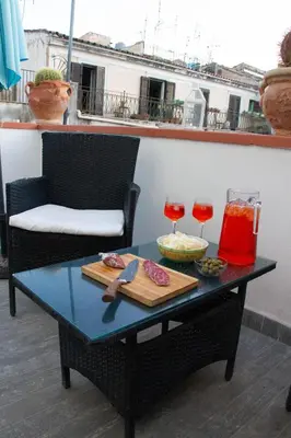 a table with two glasses of wine on a balcony at DAI MORI in Palermo