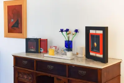a wooden dresser with flowers and a vase on it at A Casa Dell' Artista in Palermo