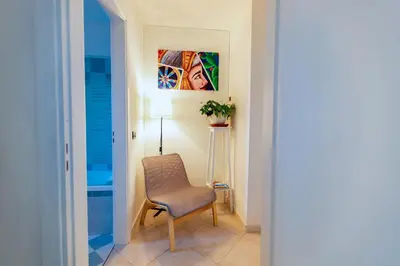 a hallway with a chair and a painting on the wall at Bianca Casa in Bolognetta