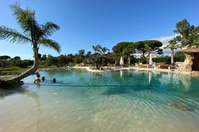 a swimming pool with people in the water at Holiday in Paradise in Balestrate