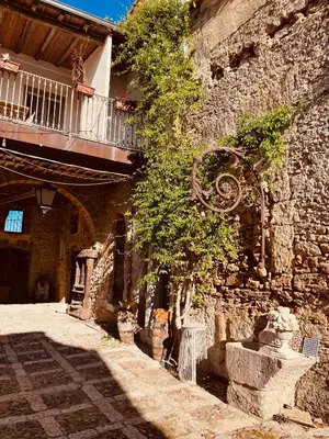 a stone building with a balcony and a tree at Baglio Colonna - Nature Noble Boutique in Partinico