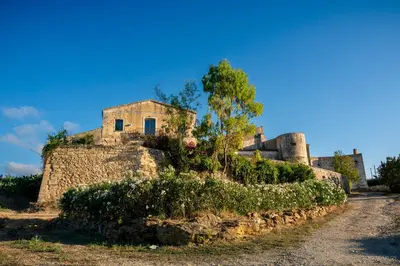 an old stone building on a dirt road at Baglio Colonna - Nature Noble Boutique in Partinico