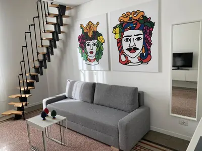 a living room with a couch and a staircase at Palazzo Caltagirone Suite in Palermo