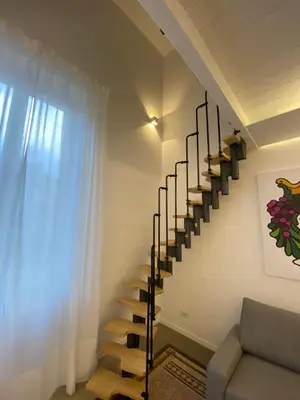 a spiral staircase in a living room with a couch at Palazzo Caltagirone Suite in Palermo
