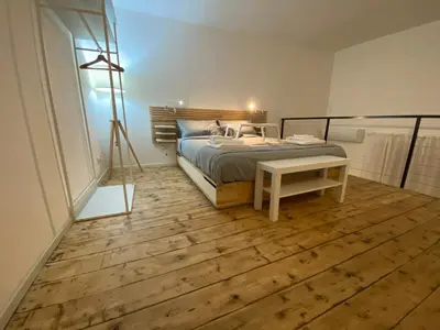 a bedroom with a bed and a table on a wooden floor at Palazzo Caltagirone Suite in Palermo