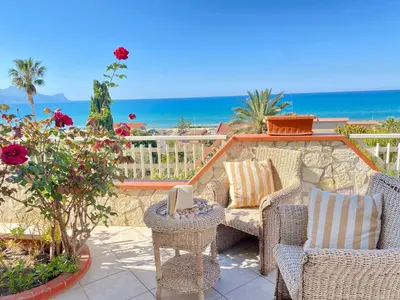 a patio with chairs and a view of the ocean at Villa Mare Giuggiola in Alcamo Marina