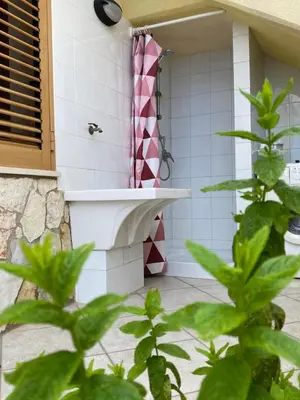 a bathroom with a shower with a pink shower curtain at Villa Mare Giuggiola in Alcamo Marina