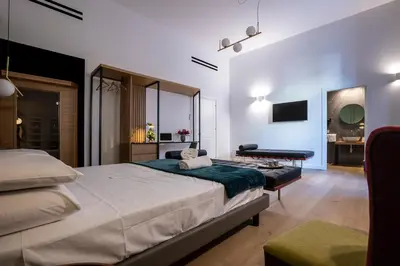 a bedroom with a bed and a desk and a television at Vespri Luxury Rooms & Suites in Palermo