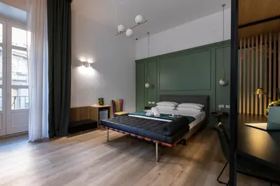a bedroom with a bed with a green headboard at Vespri Luxury Rooms & Suites in Palermo