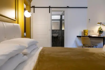 a bedroom with a large bed and a desk and a desk at Vespri Luxury Rooms & Suites in Palermo