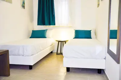 two beds with blue pillows in a room at Leone Apartments in Palermo