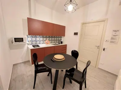 a kitchen with a table and chairs in a room at Leone Apartments in Palermo