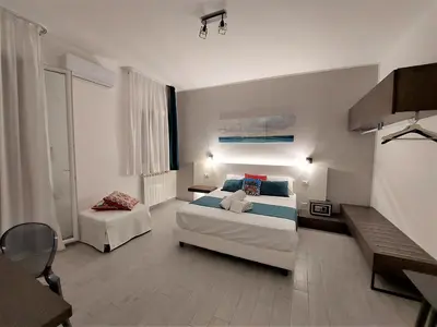 a bedroom with two beds and a couch in it at Leone Apartments in Palermo