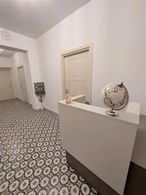 a room with a white wall and a white counter with a globe at Leone Apartments in Palermo
