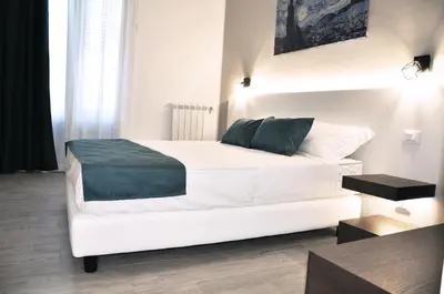 a bedroom with a white bed with a green pillow at Leone Apartments in Palermo