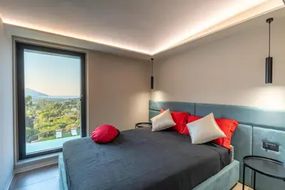 a bedroom with a bed with a large window at Villa vista mare con piscina a sfioro a Scopello in Castellammare del Golfo
