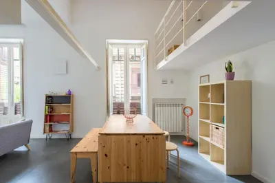 a living room with a wooden table and some windows at Casa Roma nel Cuore di Palermo by Wonderful Italy in Palermo
