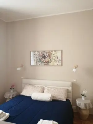 a bedroom with a blue bed and a painting on the wall at suite ruggero settimo in Palermo
