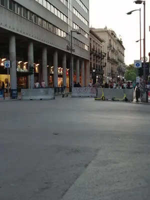 an empty street in front of a large building at suite ruggero settimo in Palermo