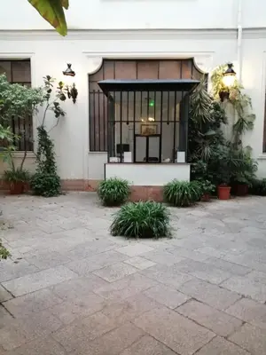 a building with a courtyard with plants in front of it at suite ruggero settimo in Palermo