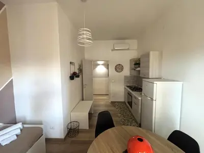 a kitchen with a table and a white refrigerator at Enne's Apartments in the heart of Palermo in Palermo