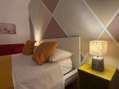 a bed with two pillows and a lamp on a table at Enne's Apartments in the heart of Palermo in Palermo