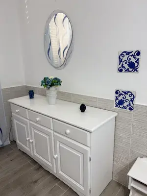 a white dresser with a mirror on the wall at Casetta Blu Mondello zona Partanna in Palermo