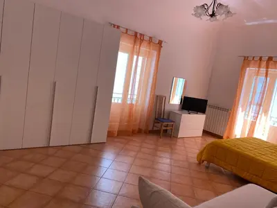 a bedroom with a bed and a desk in a room at Casa arancio in Palermo