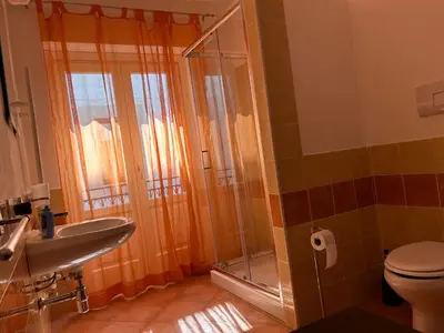 a bathroom with a shower and a toilet and a sink at Casa arancio in Palermo