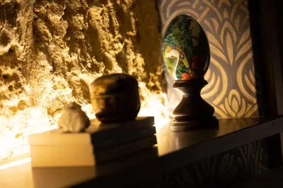 a table with a vase and a cat sitting on a shelf at Zisa Suite in Palermo