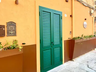 a green door on the side of a building at Zisa Suite in Palermo