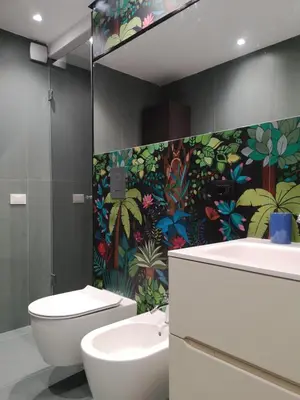 a bathroom with a toilet and a sink and a colorful wall at A NICAREDDA in Palermo