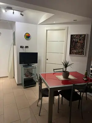 a living room with a red table and chairs and a television at ART GALLERY HOUSE La casa dell’arte in Palermo